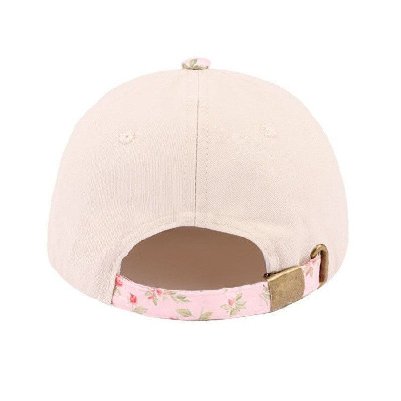 Beige cap with floral band on a white background